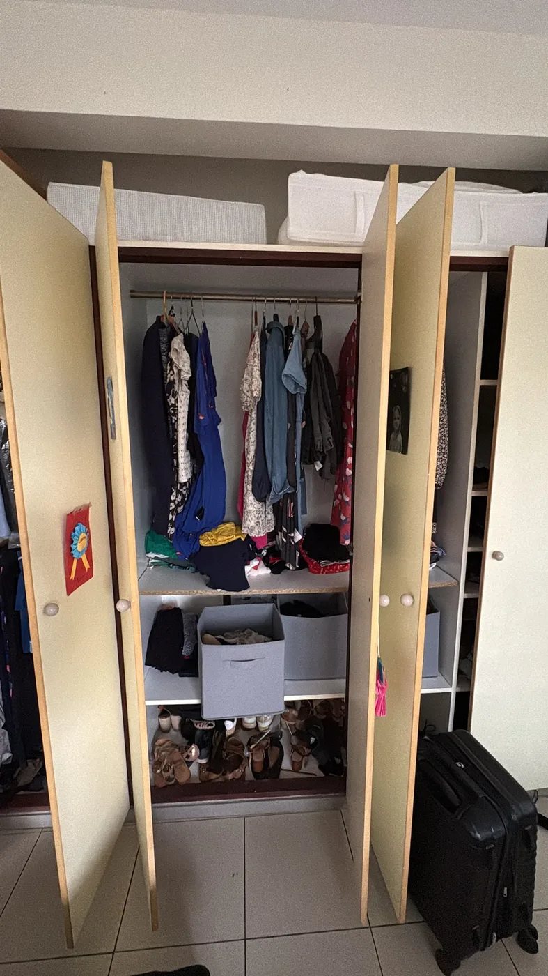 Placard de chambre avec vêtements suspendus et chaussures – avant installation DryTape Wall